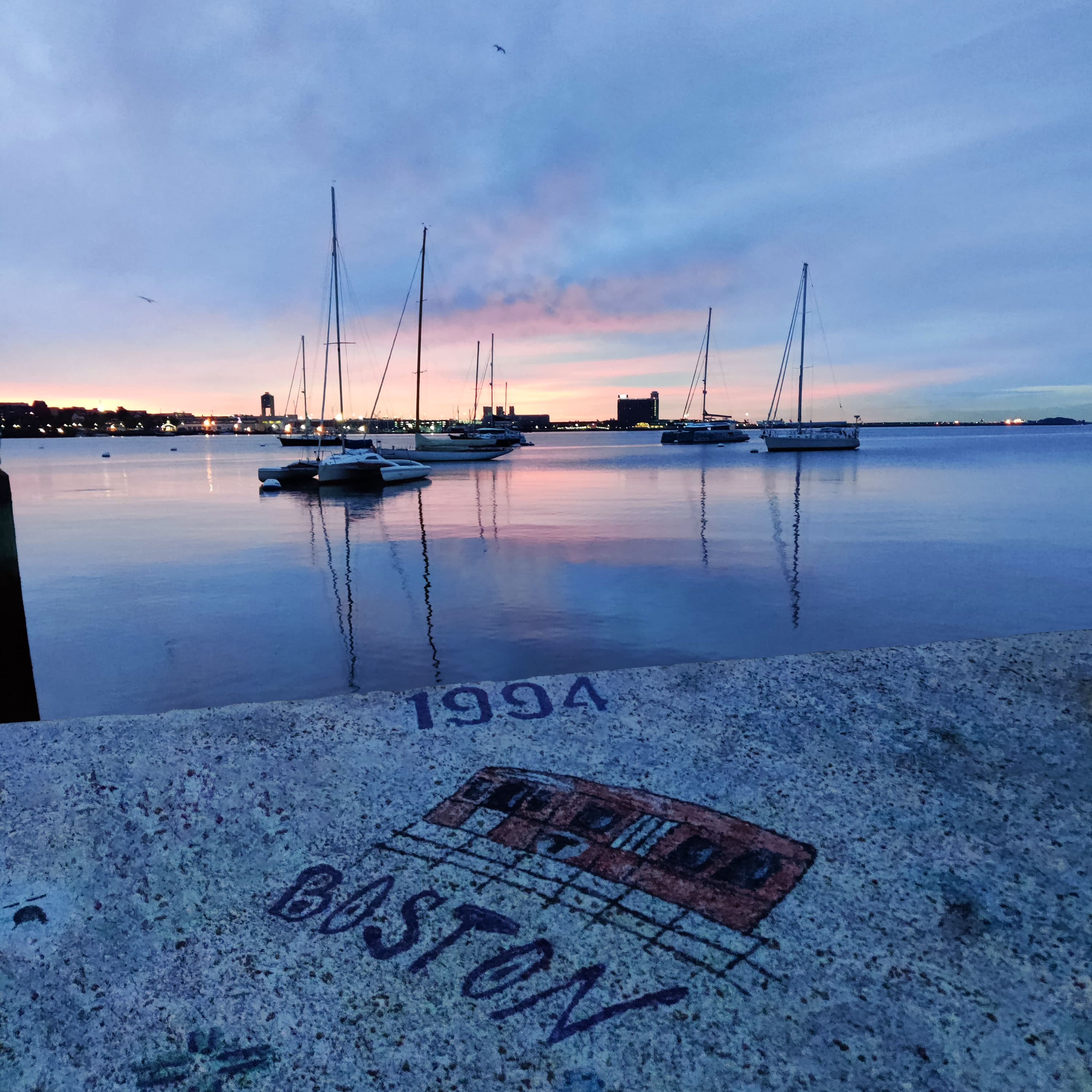 the sunrise from the boston waterfront, past some mbta-themed graffiti